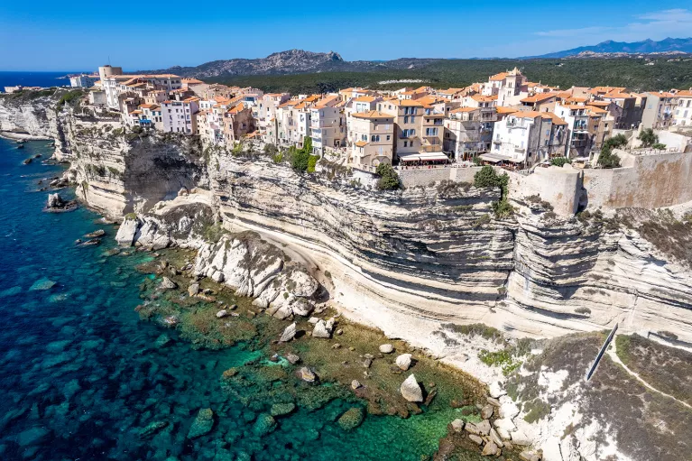 Wide shot of Corsican coastline. Houses dotting the hillside.