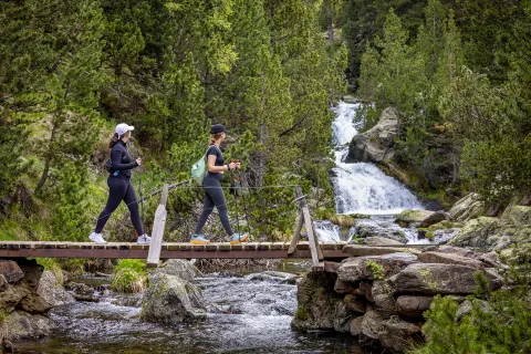 Hiking across a bridge with a waterfall in the background