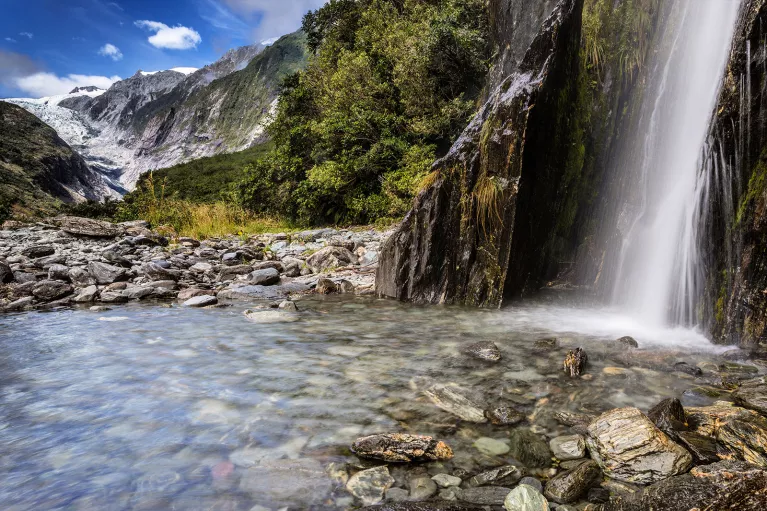 Waterfall flowing into a crystal clear river