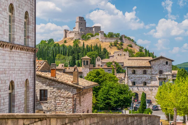 Wide shot of brick villages, large brick building on hilltop.