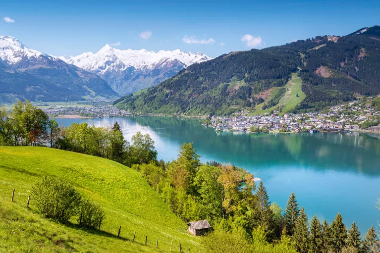 Wide shot of hilly vista, riverside town and mountains in distance. 