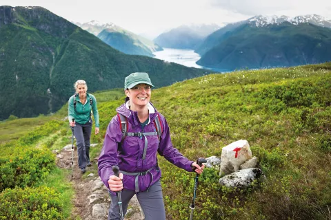 Two women hiking on a mountainous landscape.