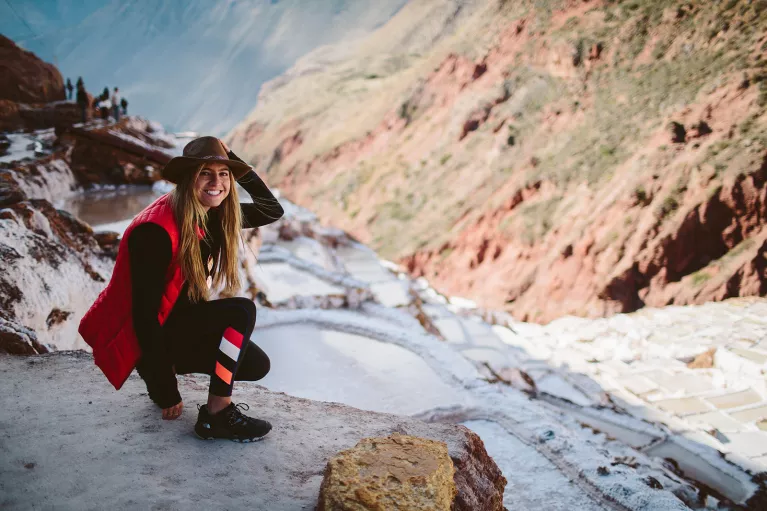 Backroads guest crouching in snow on hiking trail in Peru.