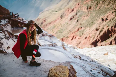 Backroads guest crouching in snow on hiking trail in Peru.