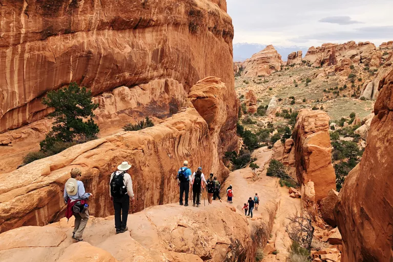 Guests hiking in national park among boulder formations