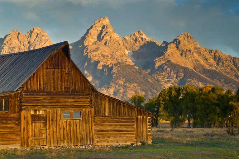 Wooden cabin with rocky mountains in background