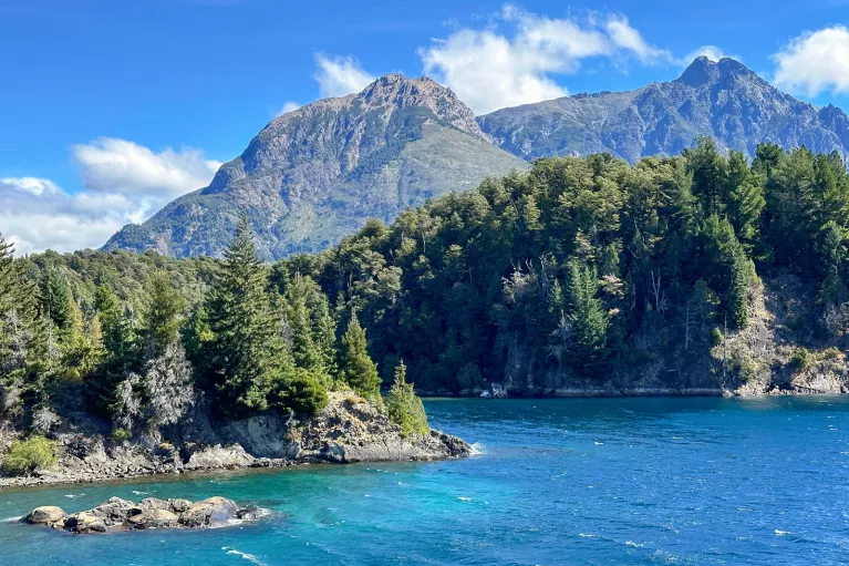 Lake surrounded by large boulders and tall trees