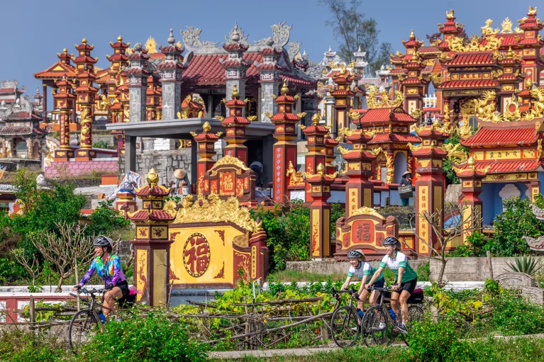 Bikers cycling through red and yellow temples