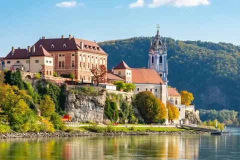 Large buildings on a small cliff overlooking a port