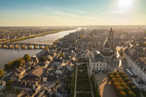 Sky view of a large, rustic town with a large bridge on the left