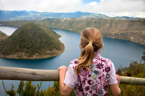 Child looking over a railing at an island