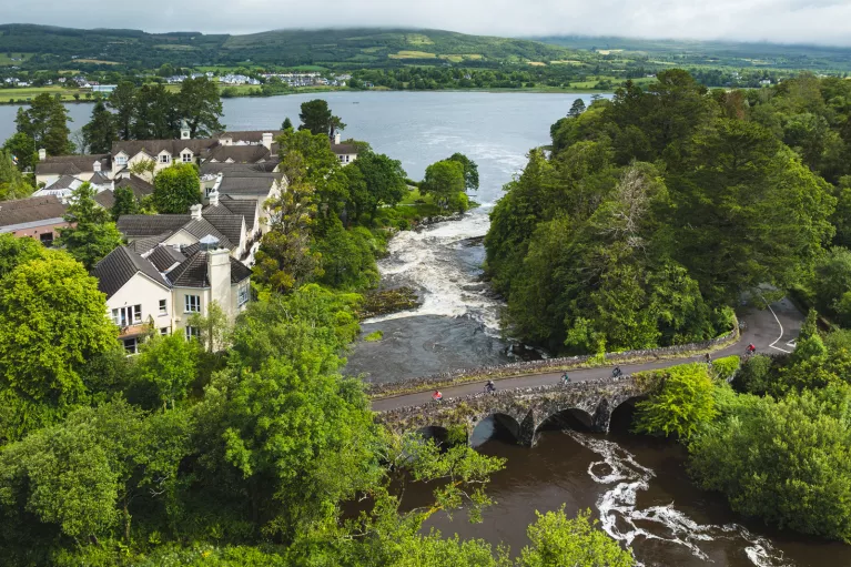 Stone bridge surrounded by trees with a river flowing underneath