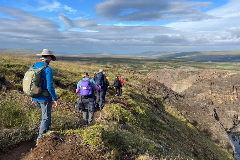 Hikers walk along a rocky mountain path