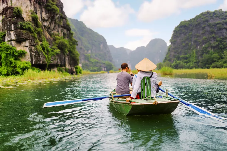 Group of people on a raft, paddling in the middle of a river