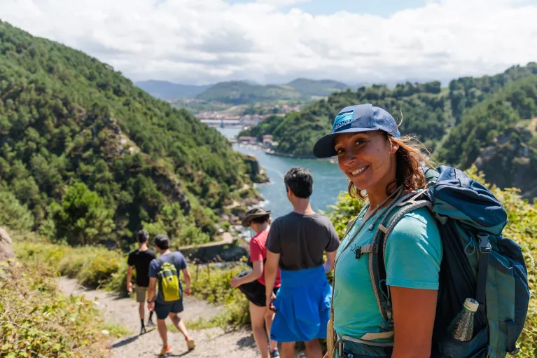 Group of people hiking with a woman turning around and smiling