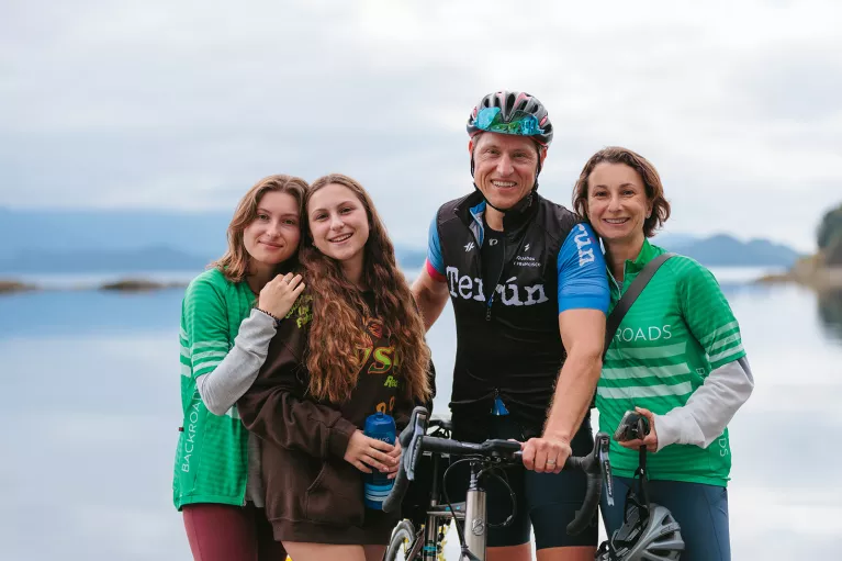 Family smiling while holding a bike in front of them