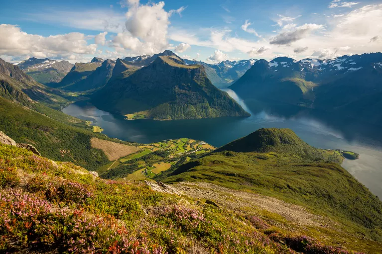 Large valley with grassy mountains and a lake in the center