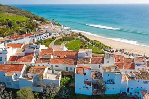 Sky view of white and brown houses next to the beach shore