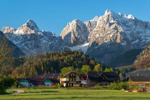 Exterior view of hotel complex buildings in a valley, with large mountains in the distance