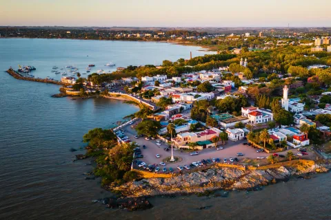 Sky view of small town by the ocean, with cars parked along the beach
