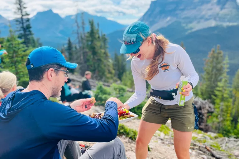 Woman passing a plate of snacks to a man