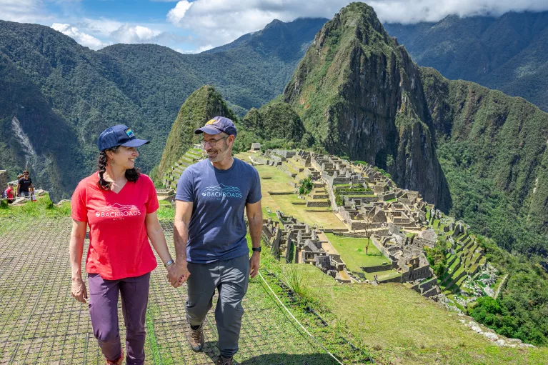 Man and women holding hands, with sights of Machu Picchu in the background