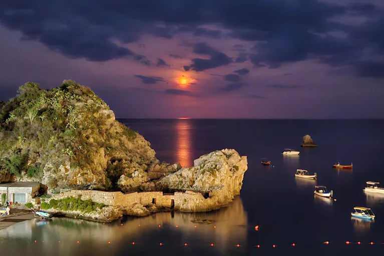 sun setting over an island