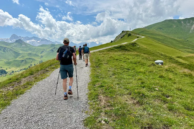 Group of people ascending a rocky trail on a mountain