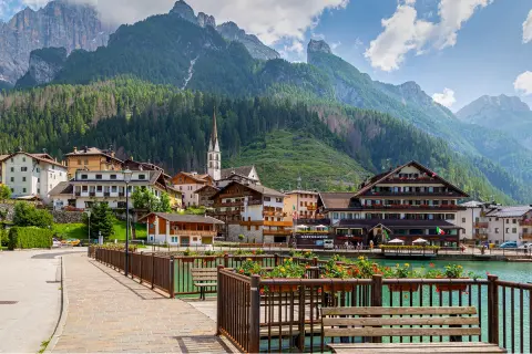 A small town, with tall mountains and trees in the background