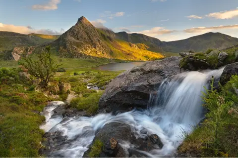 Small waterfall with a tall mountain in the background