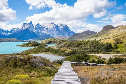 Long, wooden bridge leading to a lake in a valley