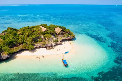 Boat by the ocean coast, with kids playing on the beach
