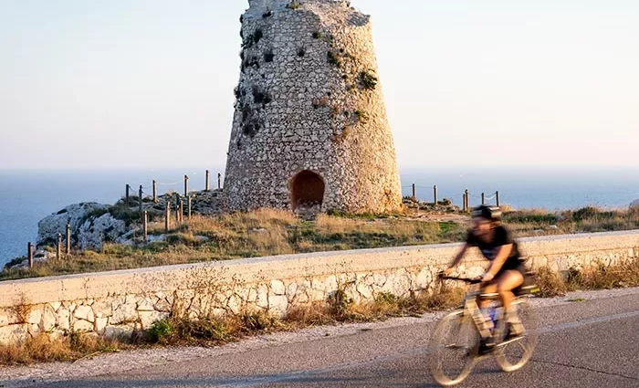 Backroads rider cycling past old stone ruin