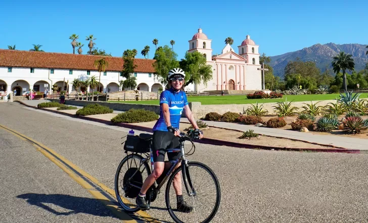 Guest posing on bike in front of cathedral/church.