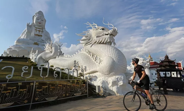 Backroads guest in front of a dragon statue in Thailand