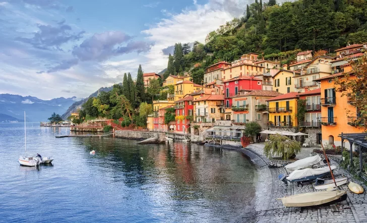 Wide shot of Lake Como coastline, colorful houses.