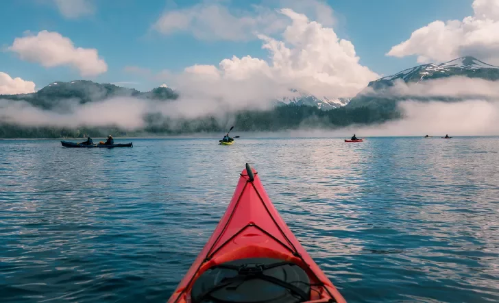 POV shot of guest kayaking, large lake, other guests, clouds etc.