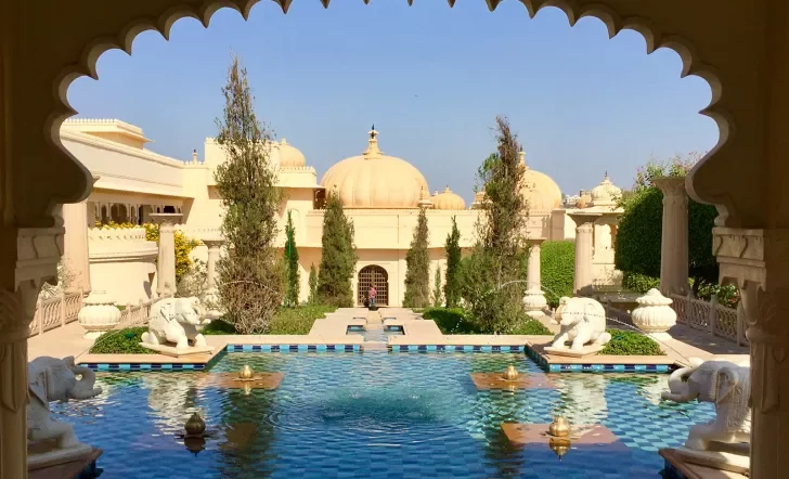 Hotel pool as seen through an ornate arch in India