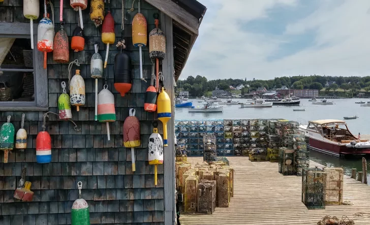 Shot of wooden fishing shack, buoys, small boats, lobster/crab traps.