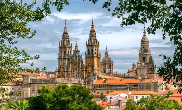 POV shot of Cathedral of Santiago de Compostela, taken from distant treeline.