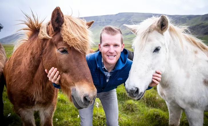 A person posing with two horses