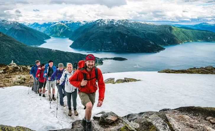 Hikers climbing a snowy ridge in Norway