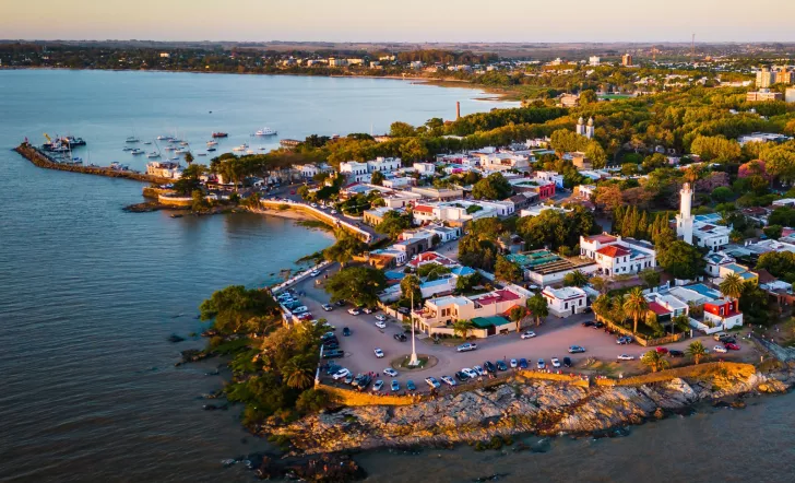 Sky view of small town by the ocean, with cars parked along the beach