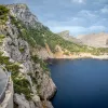 Biker riding around a bend on the coast of Mallorca.