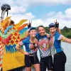 Three Backroads leaders laughing and posing in front of a dragon boat