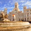 Shot of the Plaza de Cibeles, Spanish flags flying around it.