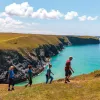 Four hikers walking up a hill in Cornwall, England