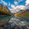 Wide shot of lake, wooden shack, mountain range, valley.
