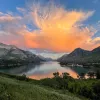 Orange sunset over lake and mountains