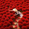 Person among bright red bundles of incense